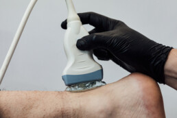 Ultrasound probe placed on a patient&rsquo;s foot during scanning